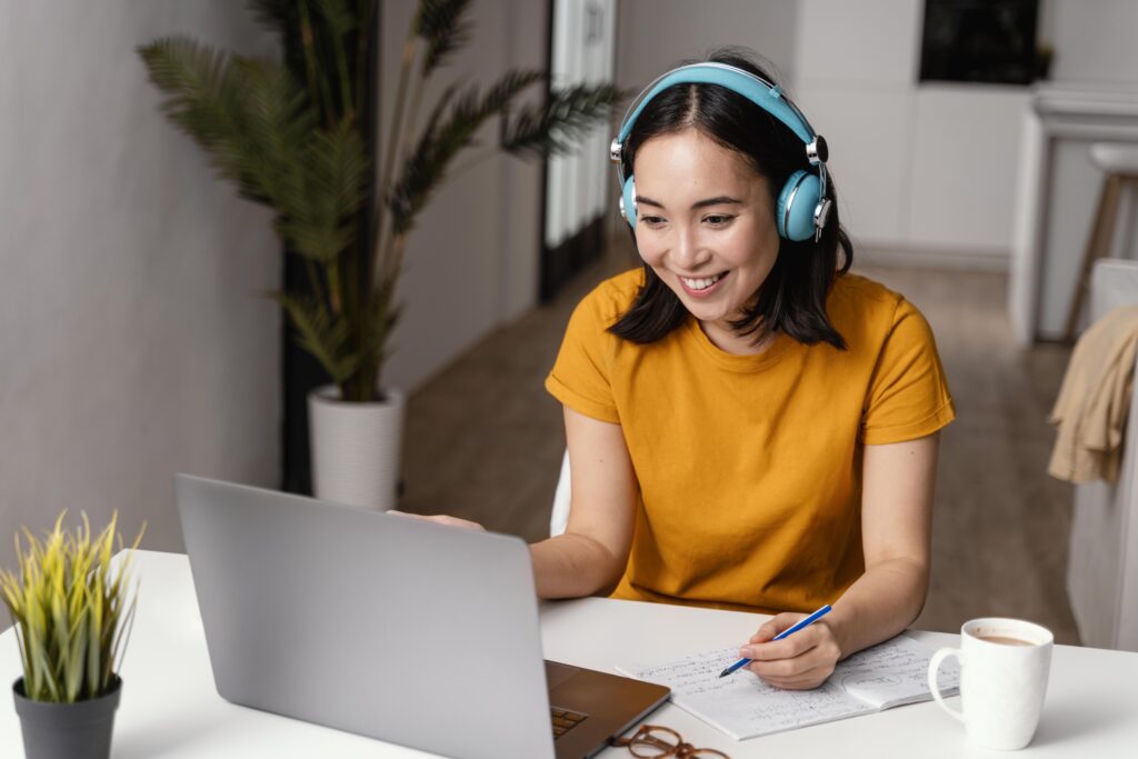A happy girl smiling while studying through an online training session, representing engaging digital education and e-learning success.